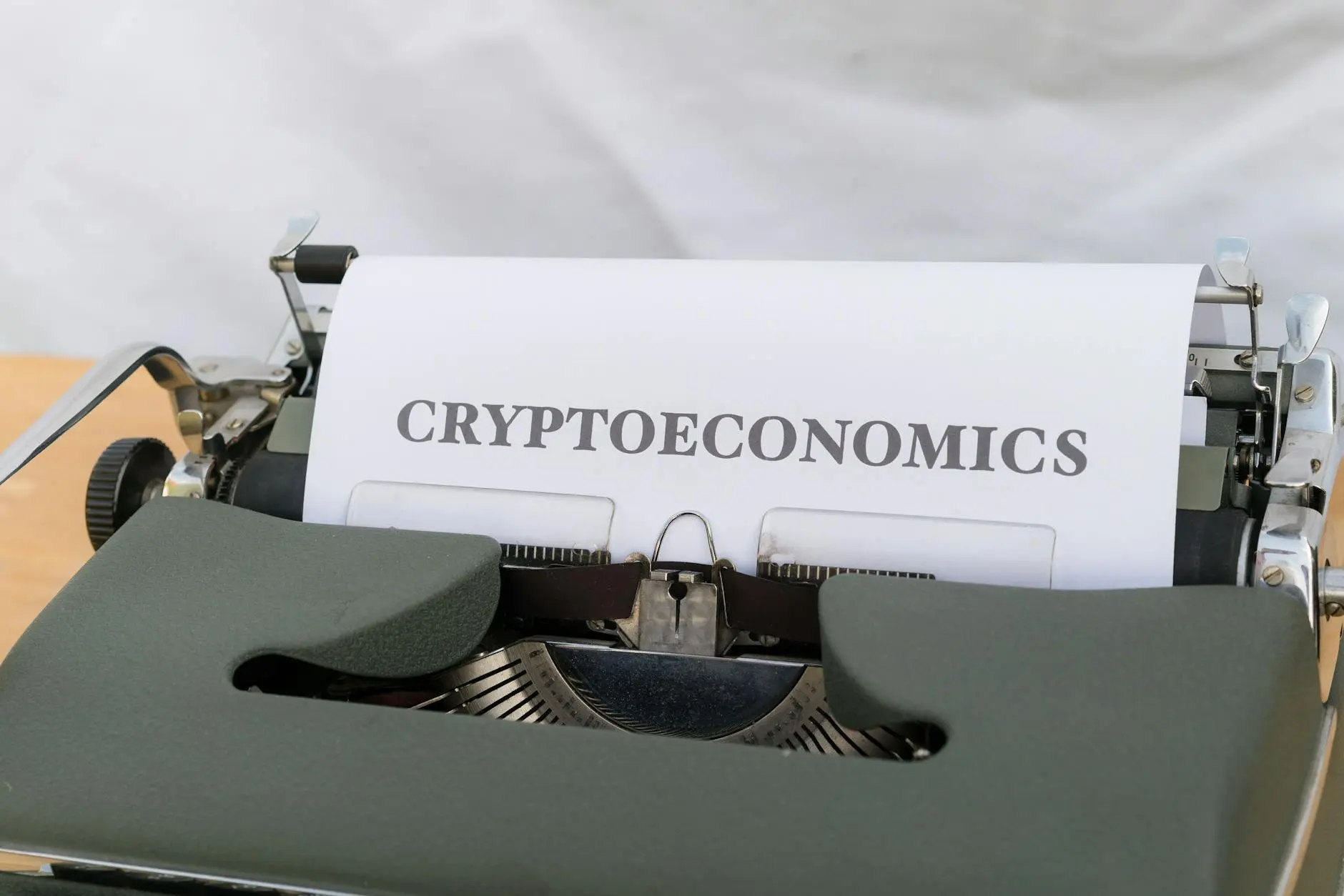A typewriter with a sheet of paper reading 'CRYPTOECONOMICS'.