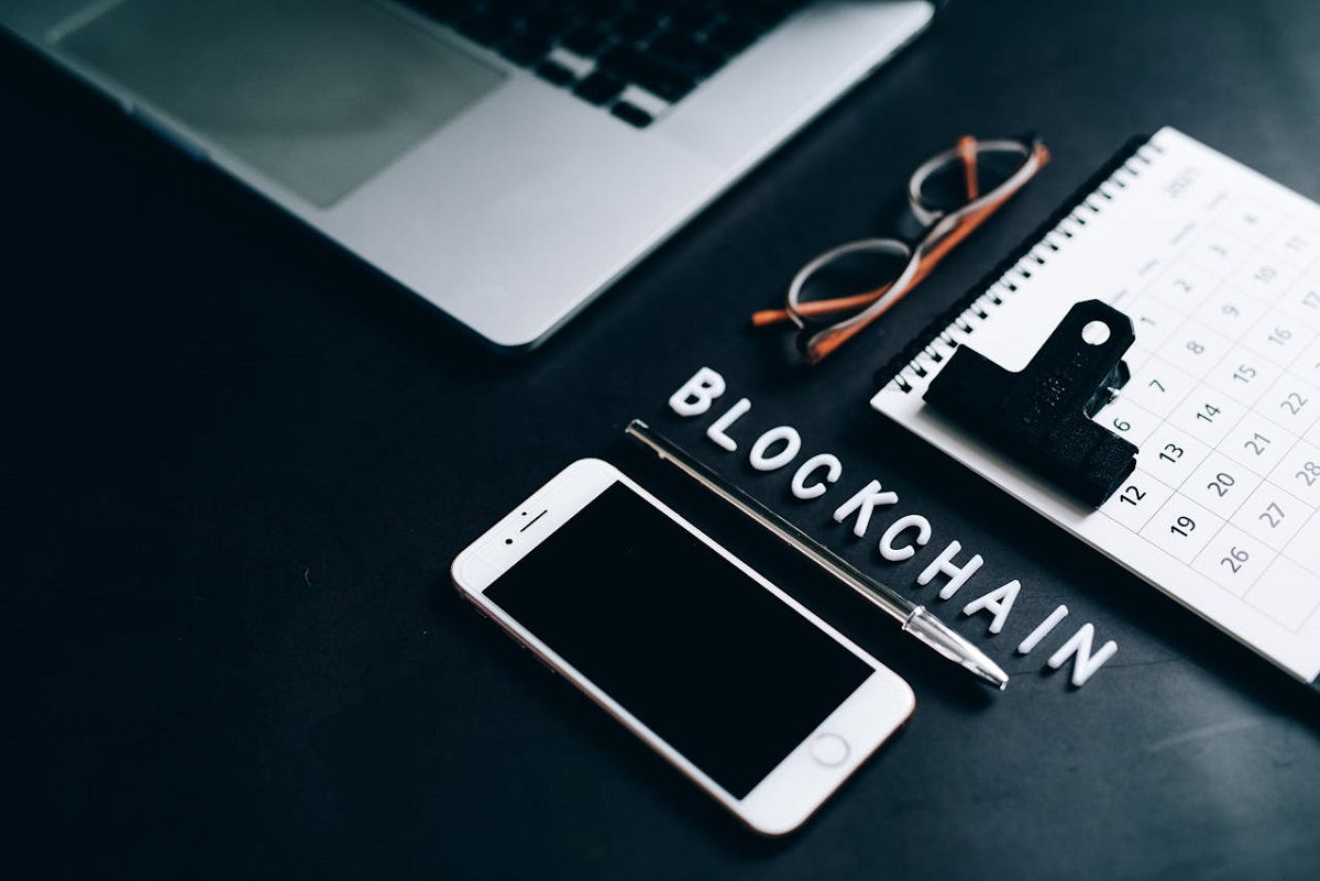 Laptop, bril, kalender, smartphone, pen en blockchain-inscriptie
